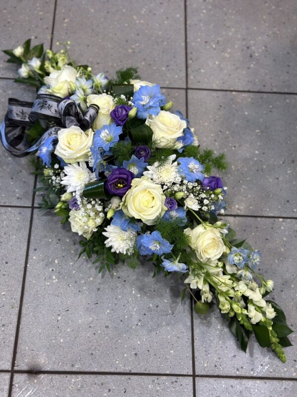 Украшение гроба в белых и синих тонах: Делфиниум, розы, еустома, хризантемы