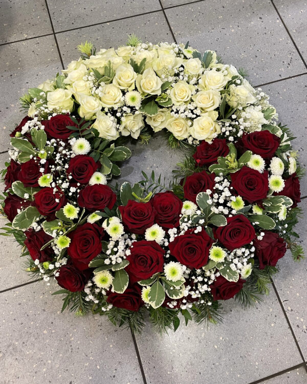 Полный цветов венок из белых и красных роз