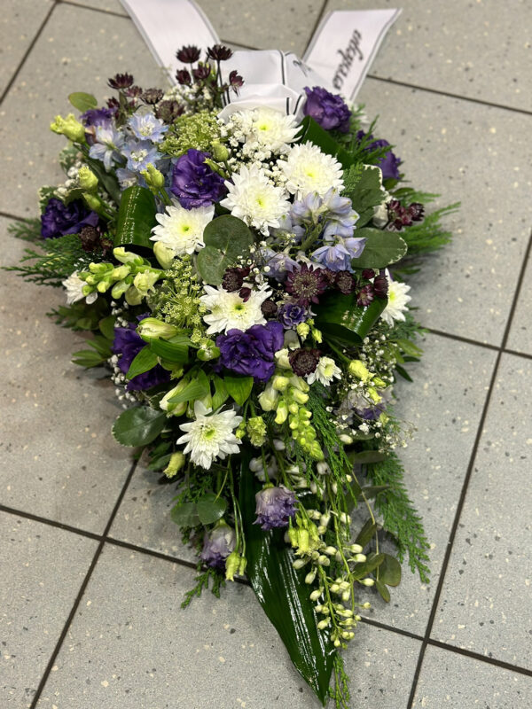 Funeral arrangement of white and purple flowers