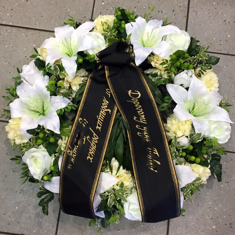 Üleni kaetud kunstlilledest pärg kuusealusel